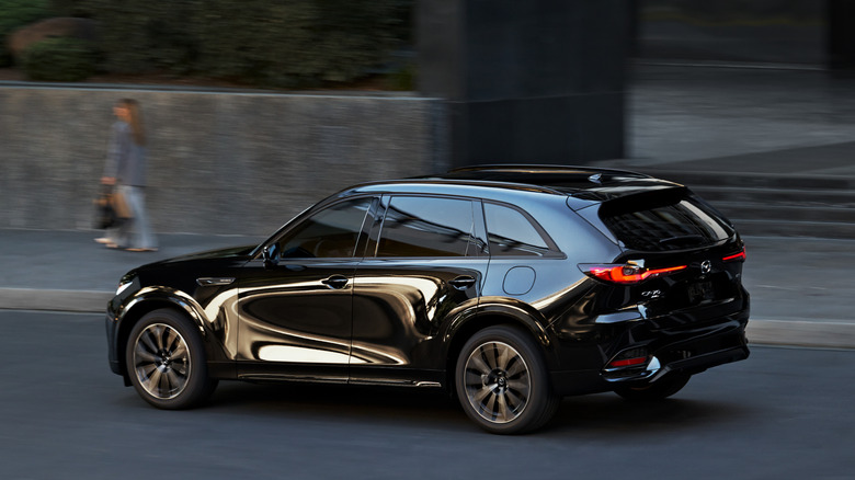 Rear 7/8 shot of 2025 Mazda CX-70 Plug-in Hybrid driving on the street