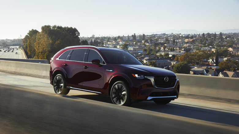 2025 Mazda CX-90 on the highway with city in background