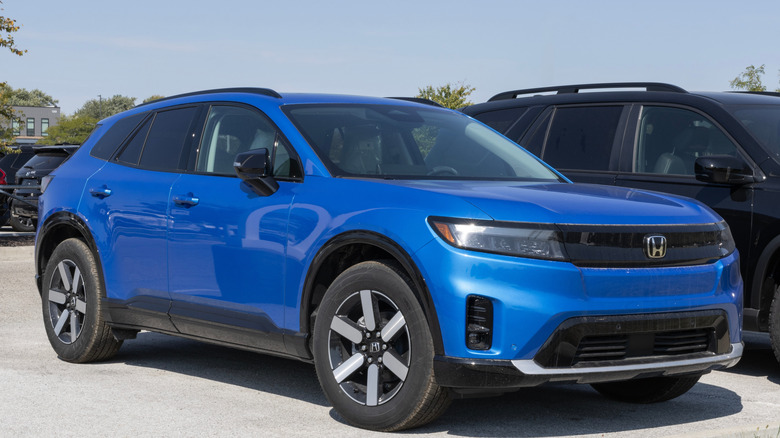 A blue Honda Prologue sits parked in a lot.