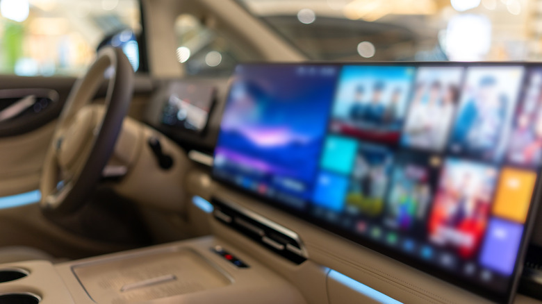 A blurred infotainment system screen on the dashboard of a car.