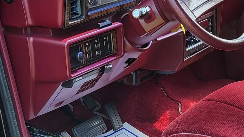 A close-up of a 1989 Dodge Caravan vent lever below the dash.