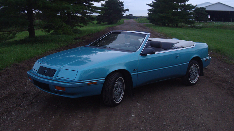 A blue1992 Chrysler LeBaron GTC Convertible parked connected a ungraded road