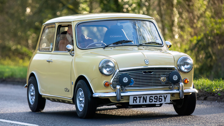 A yellow Austin Mini driving