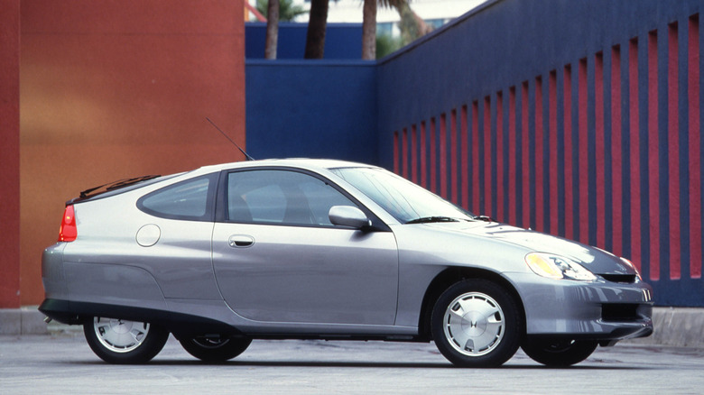 A silver 2000 Honda Insight parks in a fashionable lot.