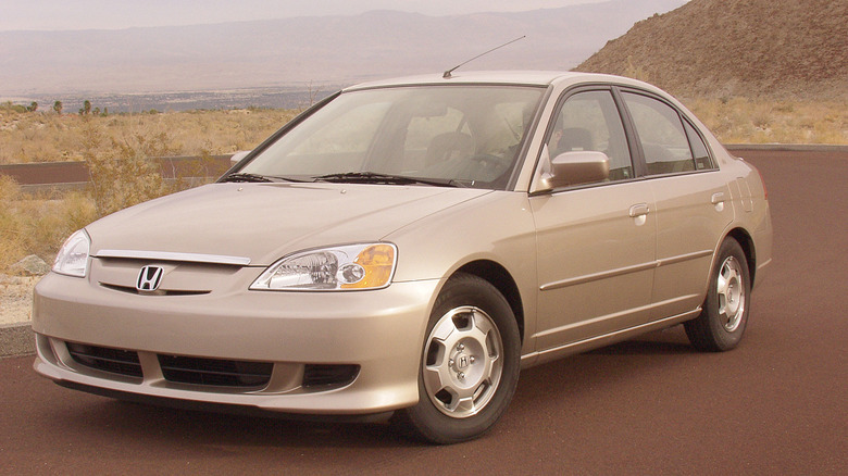 A gold 2003 Honda Civic Hybrid with mountains in the background