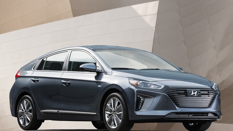 A blue 2017 Hyundai Ioniq is parked for a press photo against a fashionable backdrop.