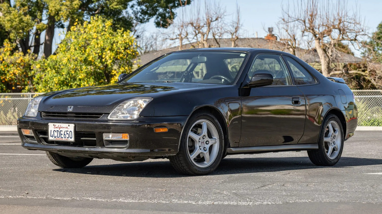 front three quarters shot of a black Honda Prelude parked in front of trees