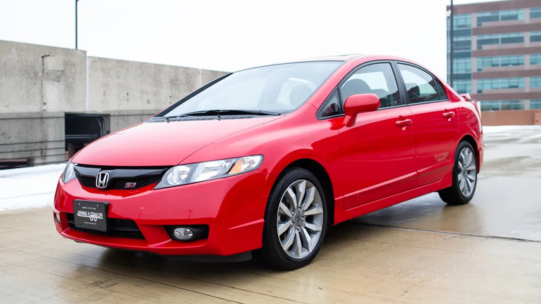 Front three quarters shot of a red Honda Civic Si on top of a parking structure