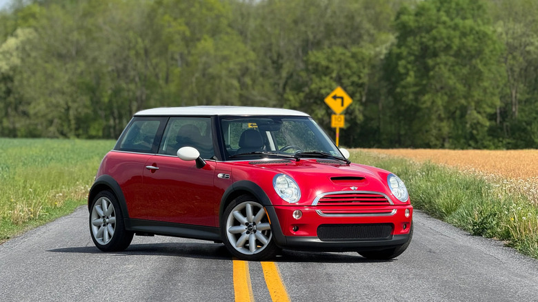 front three quarters shot of a red R53 Cooper S parked in the middle of a rural road in front of trees