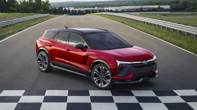 A front 3/4 view of a 2024 Chevrolet Blazer SS EV in Red Tintcoat parked near a checkered finish line