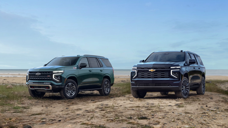 A 2025 Chevy Tahoe Z71 and a Suburban High Country parked at a beach