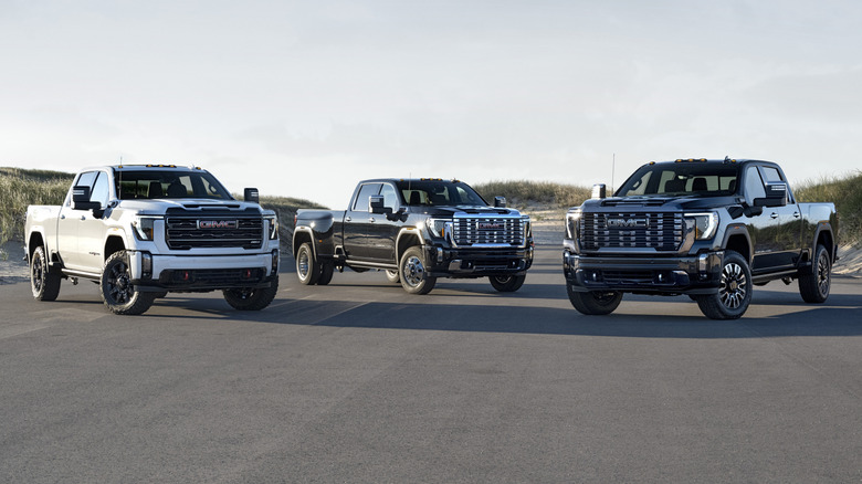 Three GMC Sierra Heavy Duty pickup trucks parked on a road