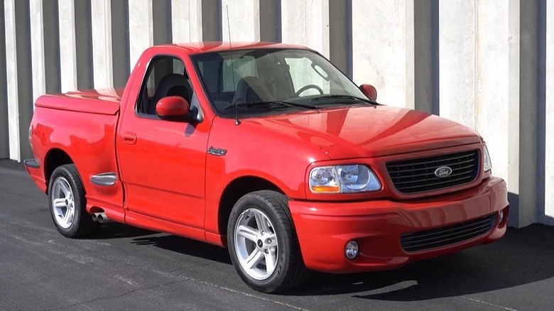 The front 3/4 view of a red 2004 Ford F-150 SVT Lightning