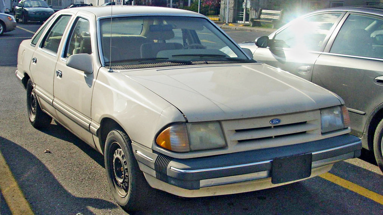 A beige 1986-1987 Ford Tempo photographed in Vaudreuil-Dorion, Quebec, Canada.
