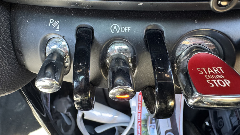 A close-up of the auto start/stop toggle switch in my Mini Cooper with its orange light on indicating it's turned off