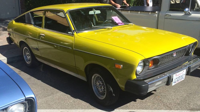 A front three-quarters of a yellow 1976 Datsun B210