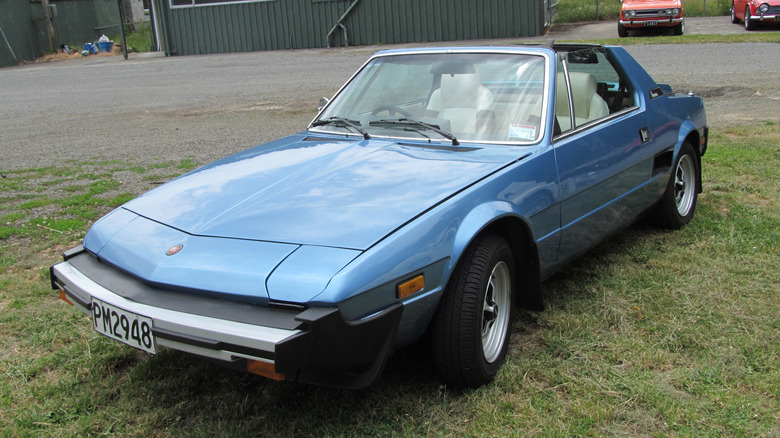 A blue 1979 Fiat X1/9 parked on a grass lot