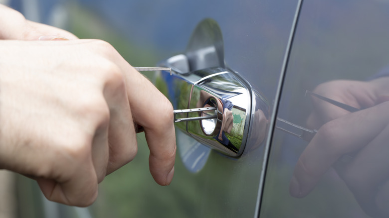 A picture of a person's hands trying to open car door