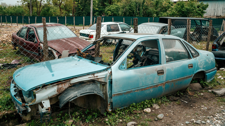 Abandoned broken down car on the street. Car dump and abandoned junk