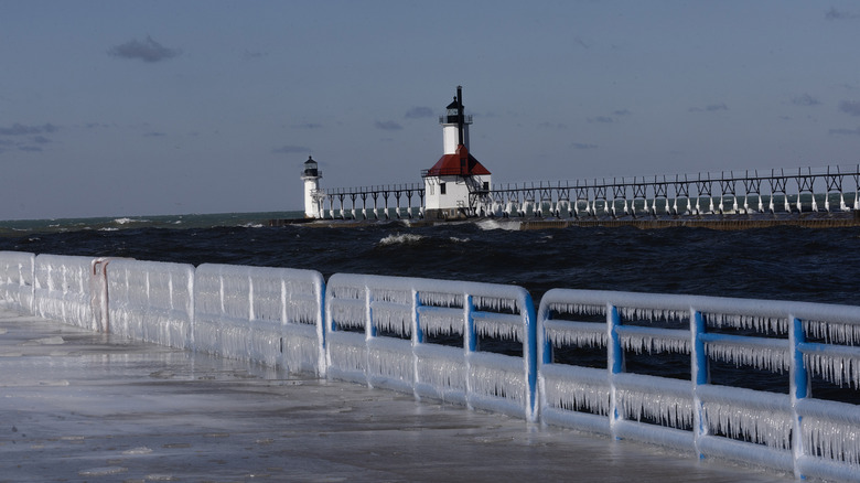 ST. JOSEPH, MICHIGAN - FEBRUARY 18: Ice builds up along a pier on Lake Michigan on February 18, 2024 in St. Joseph, Michigan. The Great Lakes shorelines have historically been ice-covered this time of year, but this winter's warm weather has led to the lowest ice cover over the lakes system since record keeping began in 1973. The loss of ice on the lakes is part of a decades-long trend which has seen the coverage drop by about 5% a year since the 1970s.