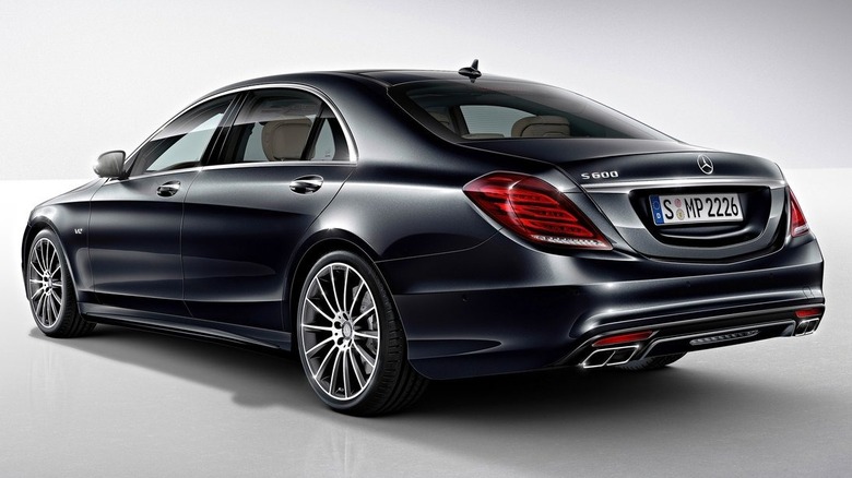 Rear three quarters shot of a black Mercedes S600 in an all-white studio room