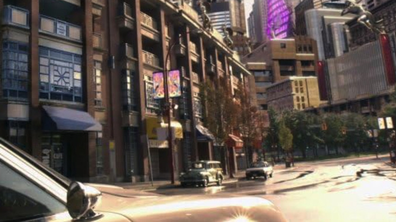 Screenshot of a futuristic city scene with a couple of cars parked on the side of the road from Caprica.