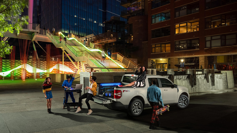 Night scene with young people crowded around a 2024 Ford Maverick