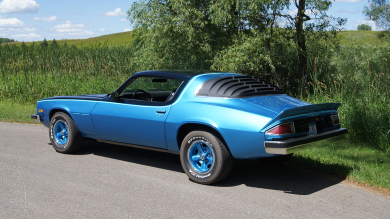 A rear three-quarters view of a blue 1975 Chevrolet Camaro RS