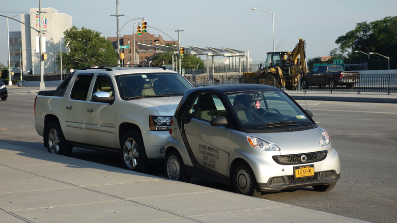A Smart car (right) and a Chevy Avalanche parked in front of the two newly-built pedestrian plazas on the north side of Queens Boulevard west of Main Street above the Van Wyck Expressway in Briarwood, Queens near Kew Gardens.