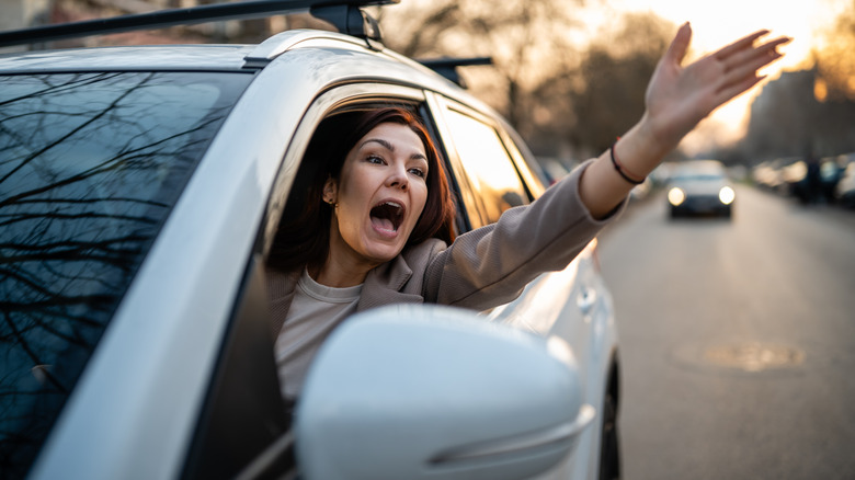 Angry woman driving car, expressing frustration and fury on the road. Experiencing road rage and traffic stress