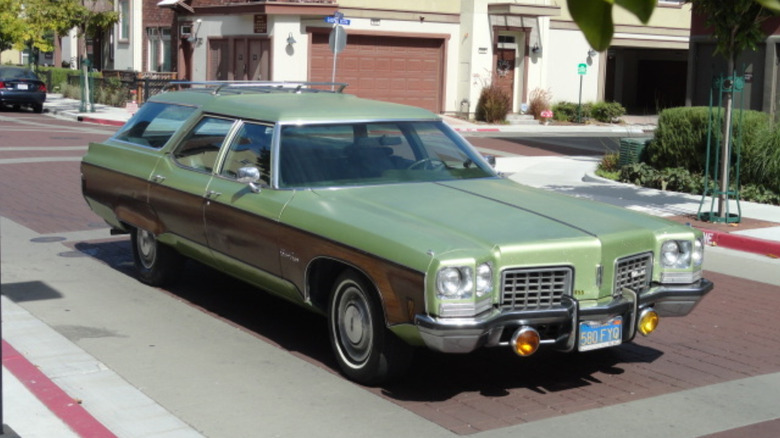 A green station wagon with wood paneling