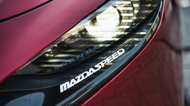 Rome, italy 29 may 2026: red mazda sports car headlight with mazdaspeed badge, sleek modern design emphasizing performance, technology, and luxury detail