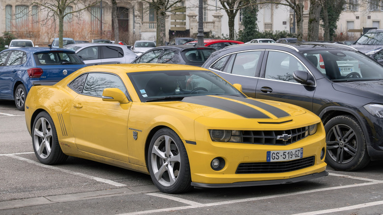 Nancy, France - February 9th 2026 : View on a yellow Chevrolet Camaro Transformers Special Edition parked on a parking lot surrounded by other cars. The fifth-generation Chevrolet Camaro is a pony car that was manufactured by American automobile manufacturer Chevrolet between 2010 and 2015.