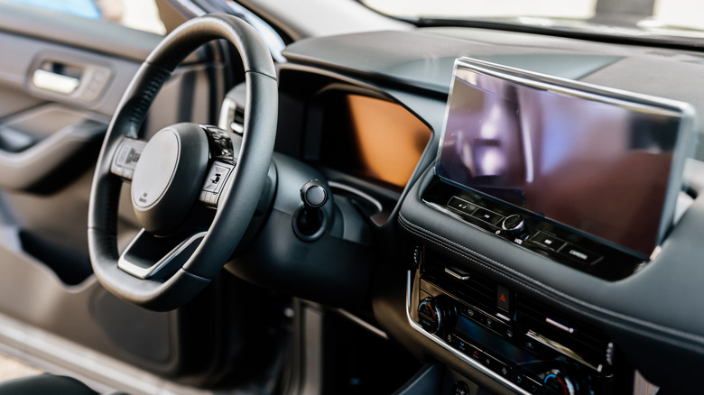 Concept of stylish design, shopping, and car parts. Close-up of a car steering wheel in a modern new car. The interior of a stylish new car.