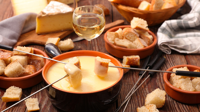 Traditional cheese fondue with bread and glass of wine