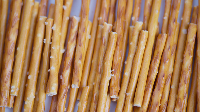 Golden pretzel closeup. Studiolit image showcasing salted pretzel sticks. Highquality photograph emphasizing textured salted pretzel sticks under warm studio lighting