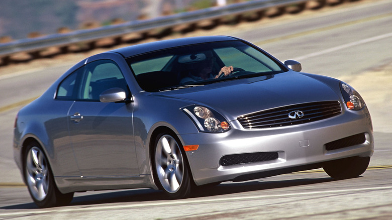 Front three quarters shot of a silver G35 driving around a corner in front of guard rails