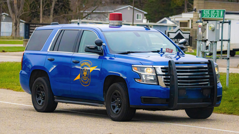 A Michigan State Police blue SUV captured in motion while patrolling traffic along the roadway.