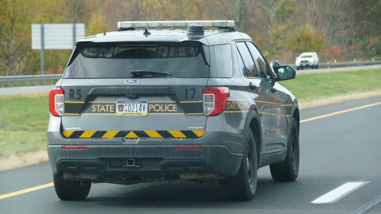 The rear view of a Pennsylvania State Trooper Ford Explorer patrol vehicle in motion on a highway.