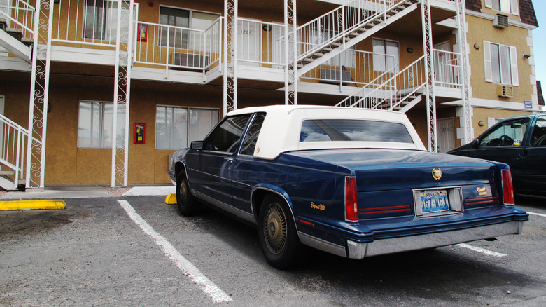 A blue Cadillac at a motel