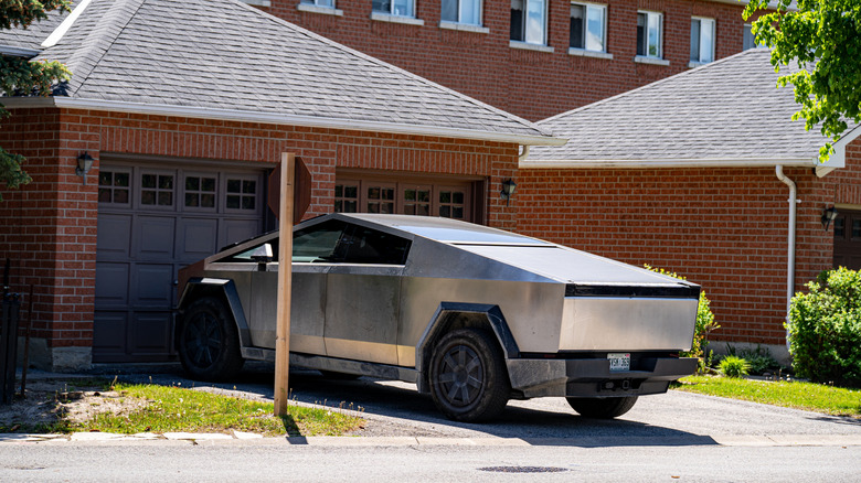 A Tesla Cybertruck parked in front of a garage