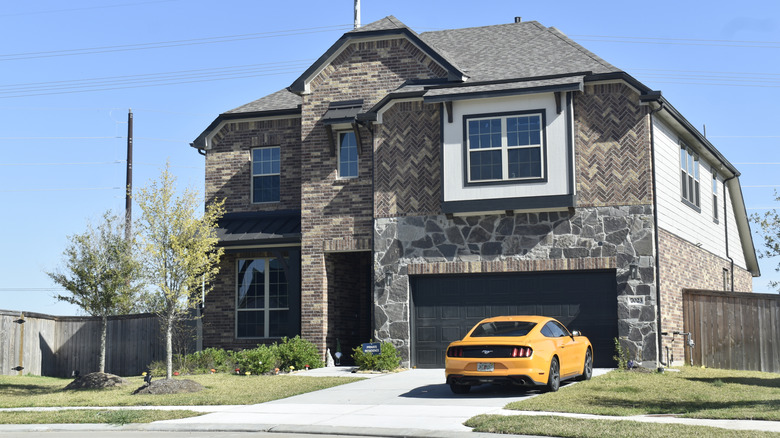 A yellow Ford Mustang in a driveway