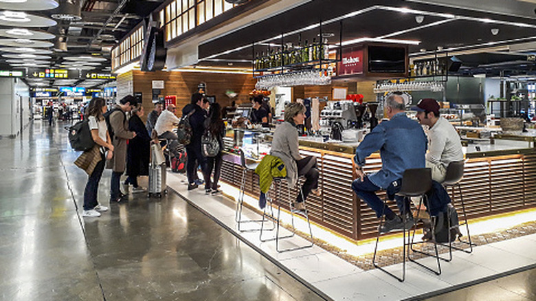 People sitting at a bar in an airport concourse