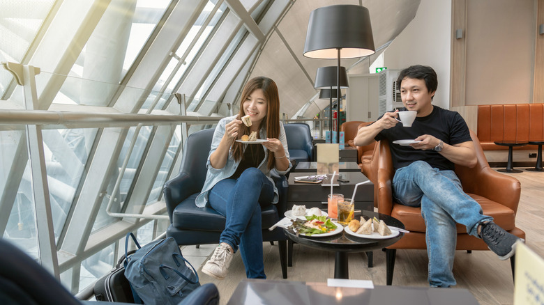 Two people enjoy snacks at an airport lounge