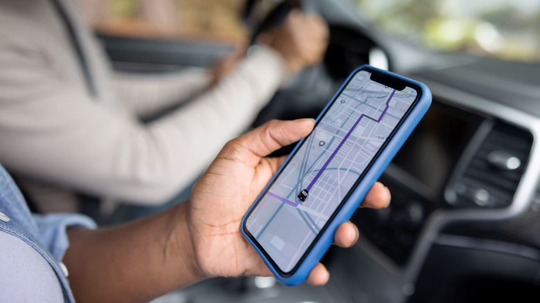 A black hand holding a phone with directions