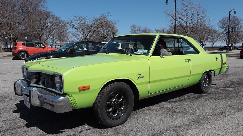 A bright green Dodge Dart Swinger in a parking lot in New York.