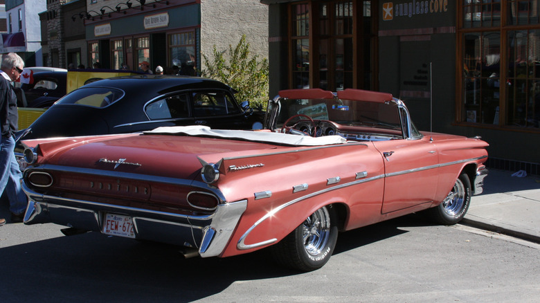A beautiful pink convertible Pontiac Parisienne parked along a downtown curb for a car show in Canada.