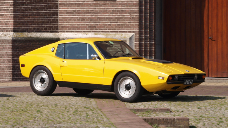 A yellow Saab Sonnet in front of an old Dutch building.
