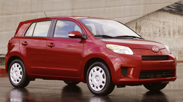 A red Scion xD parked in front of a building