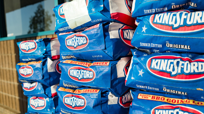 Bags of Kingsford charcoal stacked up outside of a store